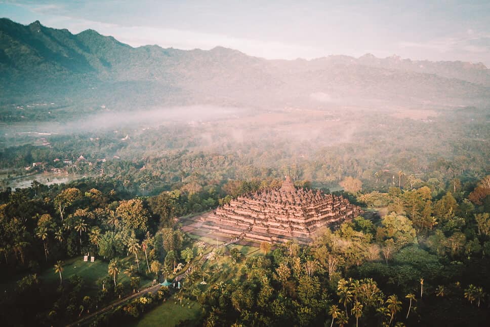 Drone shot of the Borobudur complex by sunset