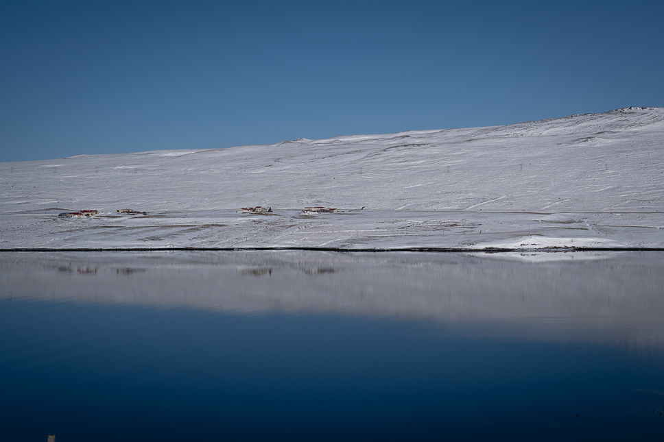 Prachtig winterlandschap met enkele huizen langs de Arctic Coast Way in IJsland