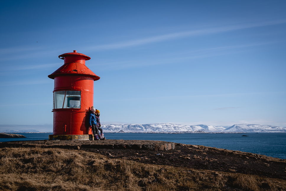 Kinderen leunen tegen de Súgandisey Island Vuurtoren in Stykkishólmur in Snaefellsnes