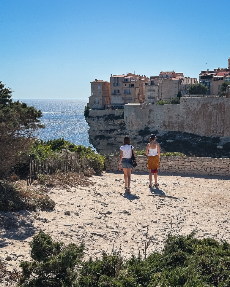 Girls walking towards the view of the citadel of Bonifacio in Corsica.