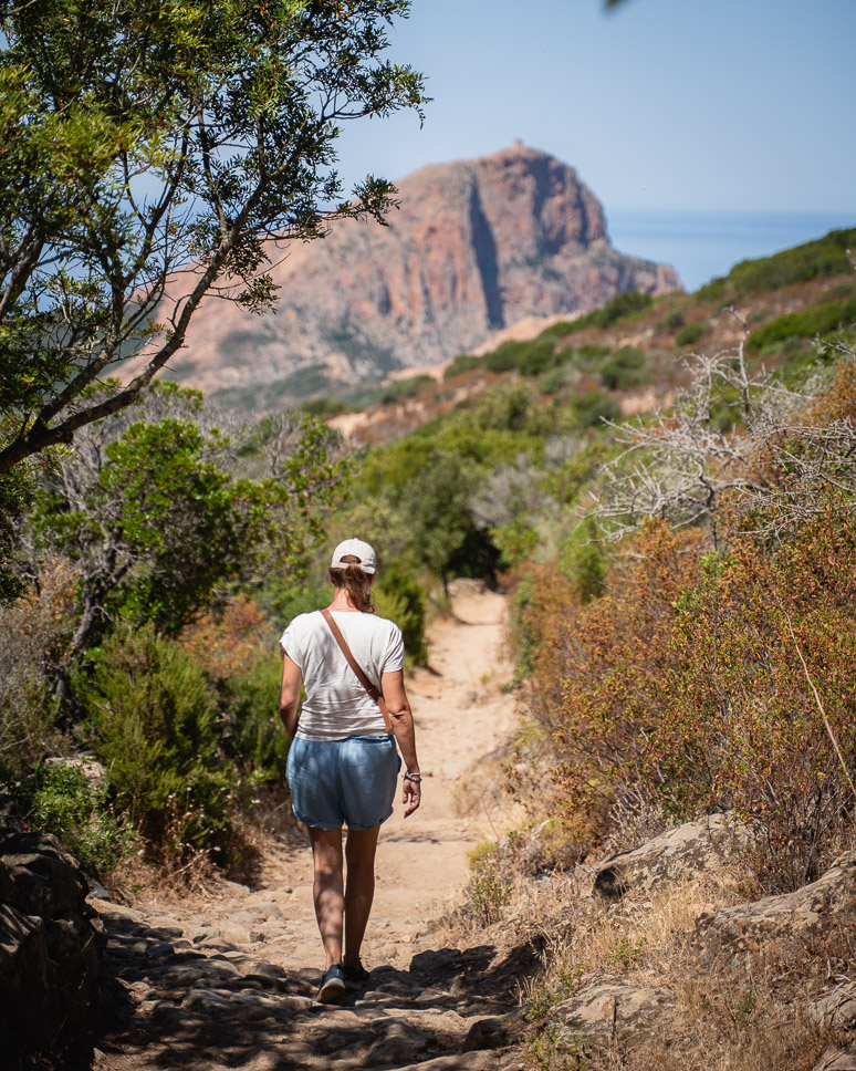 Woman walking on the path to Capo Rosso in Corsica.