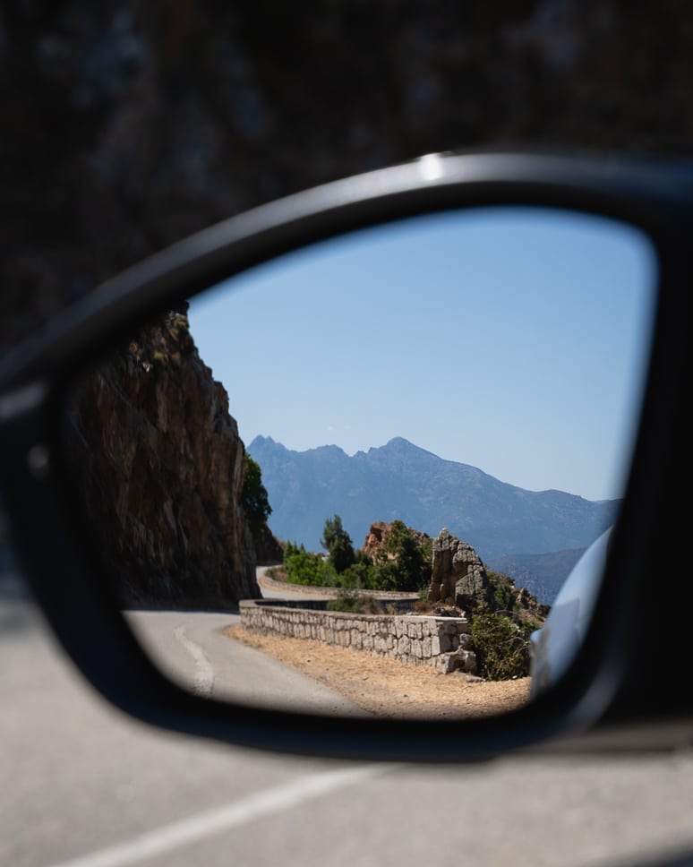 Zicht op de bochtige bergwegen in Corsica vanuit de huurwagen