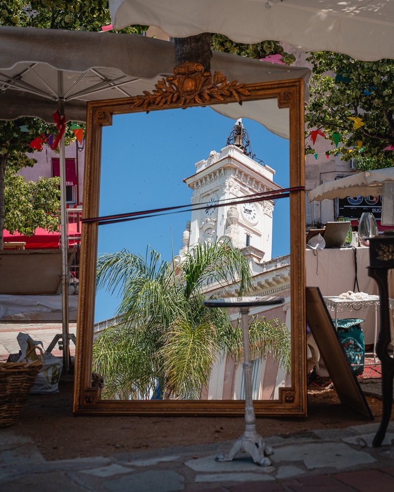 Spiegelbeeld van het stadhuis op rommemarkt op Place Foch in Ajaccio