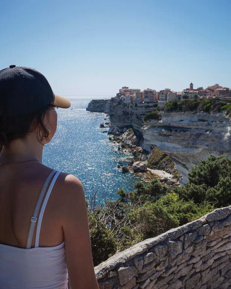 Girl looking out at the citadel of Bonifacio in Corsica from the walking path.